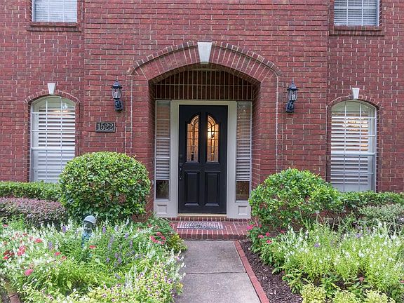 Manicured front yard leads into welcoming entry.