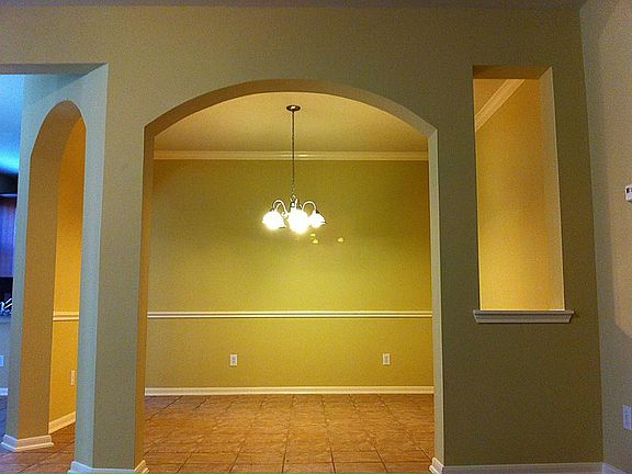 FORMAL DINING FRAMED WITH ARCH OPENING.