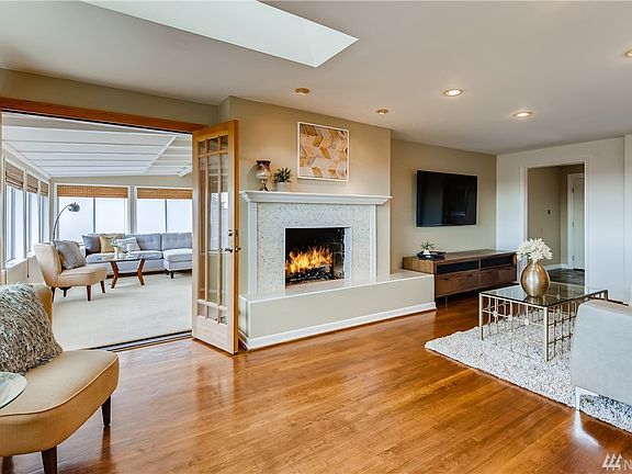 Gorgeous living room with gas fireplace and French doors leading to sunroom/den.