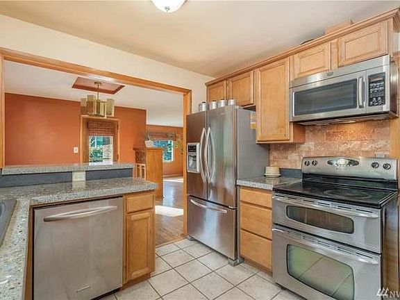 Cozy kitchen with all appliances (paint color is now light moss green and dining room wall is gray). Cool agate and concrete counters!