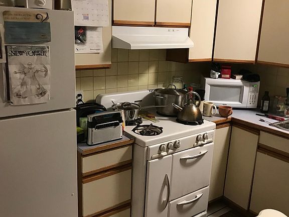 Kitchen cooking area. Stove, microwave, refrigerator.