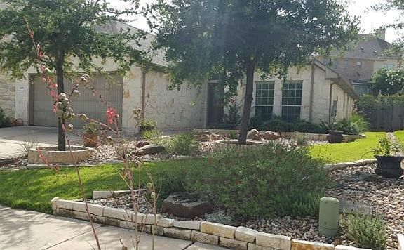Beautiful zeroscaped landscaped yard. (Pots w/plants do not convey) full sprinkler system. 4 side stone.