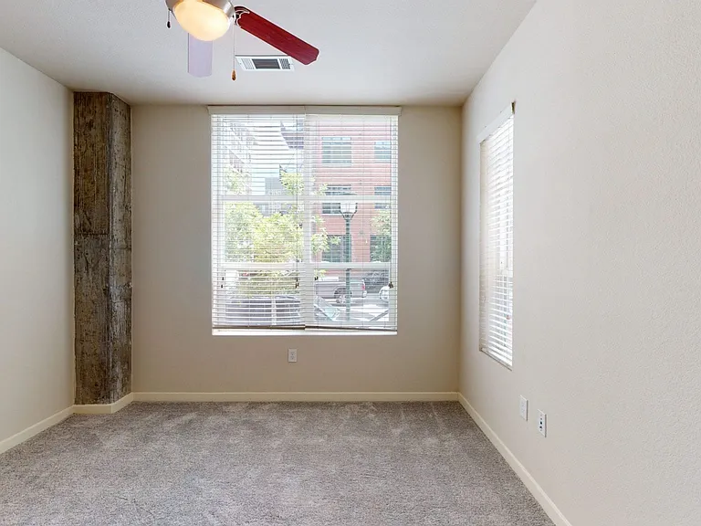 Spacious apartment bedroom with plush carpet flooring.