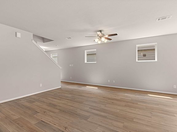 An additional view of the family room featuring gorgeous flooring, ceiling fan with light and multip