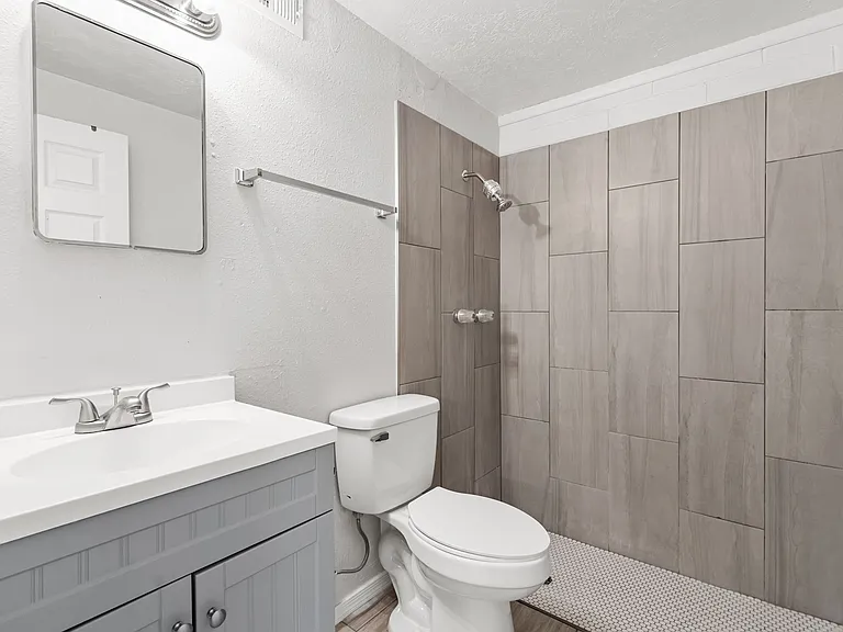Beautifully tiled primary bathroom with a walk-in shower and modern vanity.