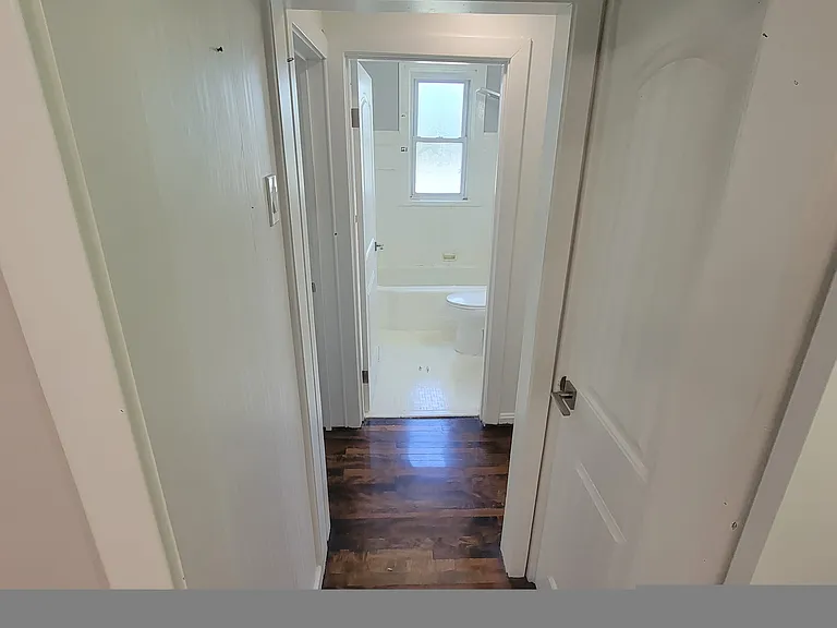 Hallway off of living room that leads to bedrooms and bathroom