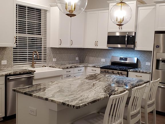 kitchen with granite countertop , nicely designed back splash.