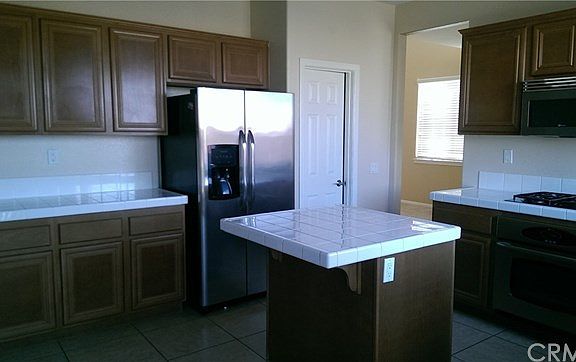 Kitchen has island and plenty of cabinetry. Walk in pantry.
