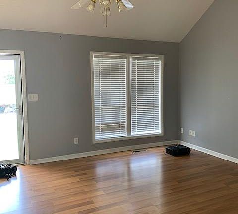 Living room with view of double windows and front entrance.