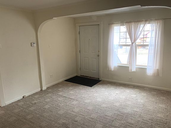 LIVING ROOM. FRONT ENTRANCE VISIBLE ON THE LEFT SIDE OF THE FAR WALL