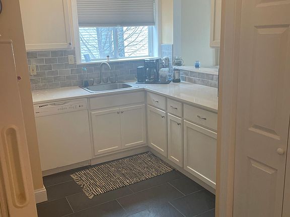 Kitchen has brand new quartz countertops and porcelain tile floors. Includes stove, refrigerator, microwave, and dishwasher.
