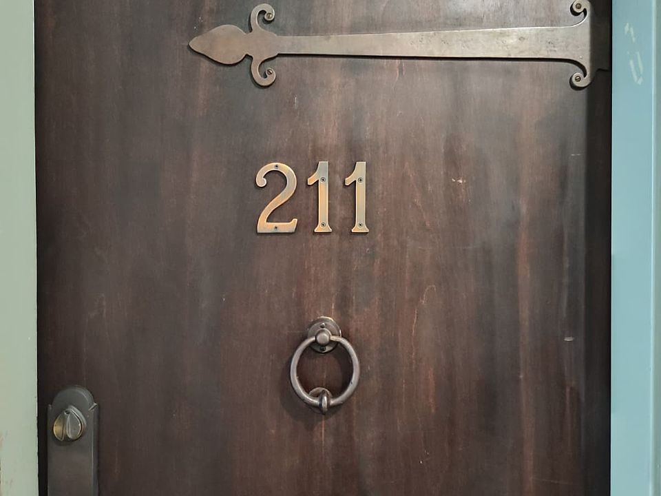 Unit door with charming hardware accents and door knocker