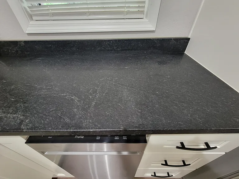 Granite countertop in kitchen over stainless dishwasher
