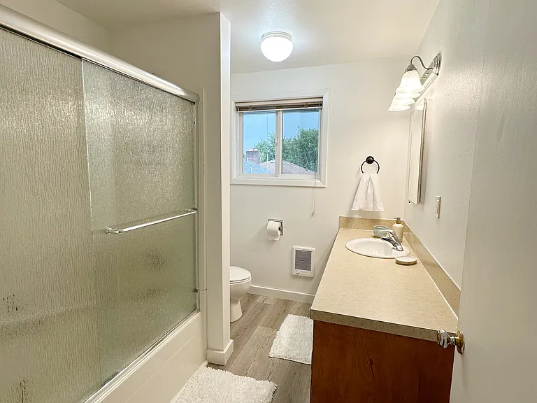 Bathroom with shower/tub combo and large vanity.
