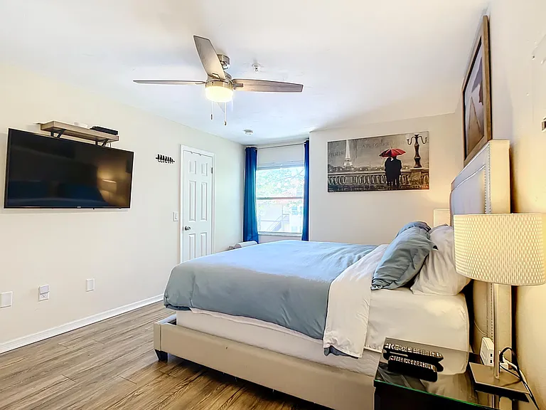 Primary bedroom with comfortable king bed, wall-mounted smart TV (with cable)