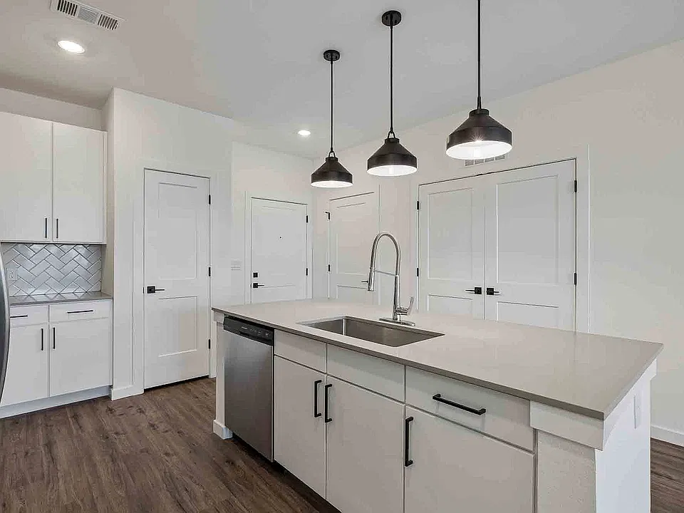 The B1 island puts the sink, dishwasher, and prep space in one run, with three pendants overhead.