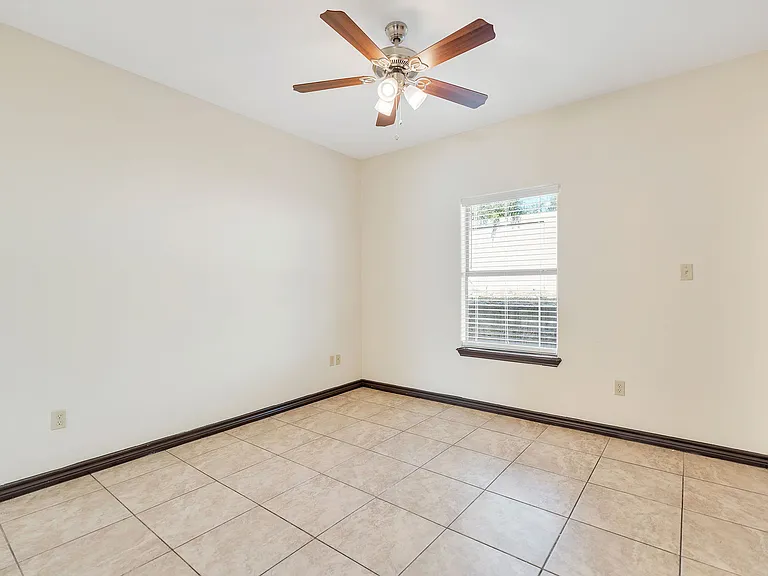 La Joya Apartments room with tile flooring and a ceiling fan, highlighting a modern interior design