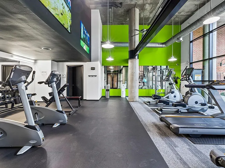 Fitness center featuring cardio equipment, strength training area, rubber flooring, and expansive windows