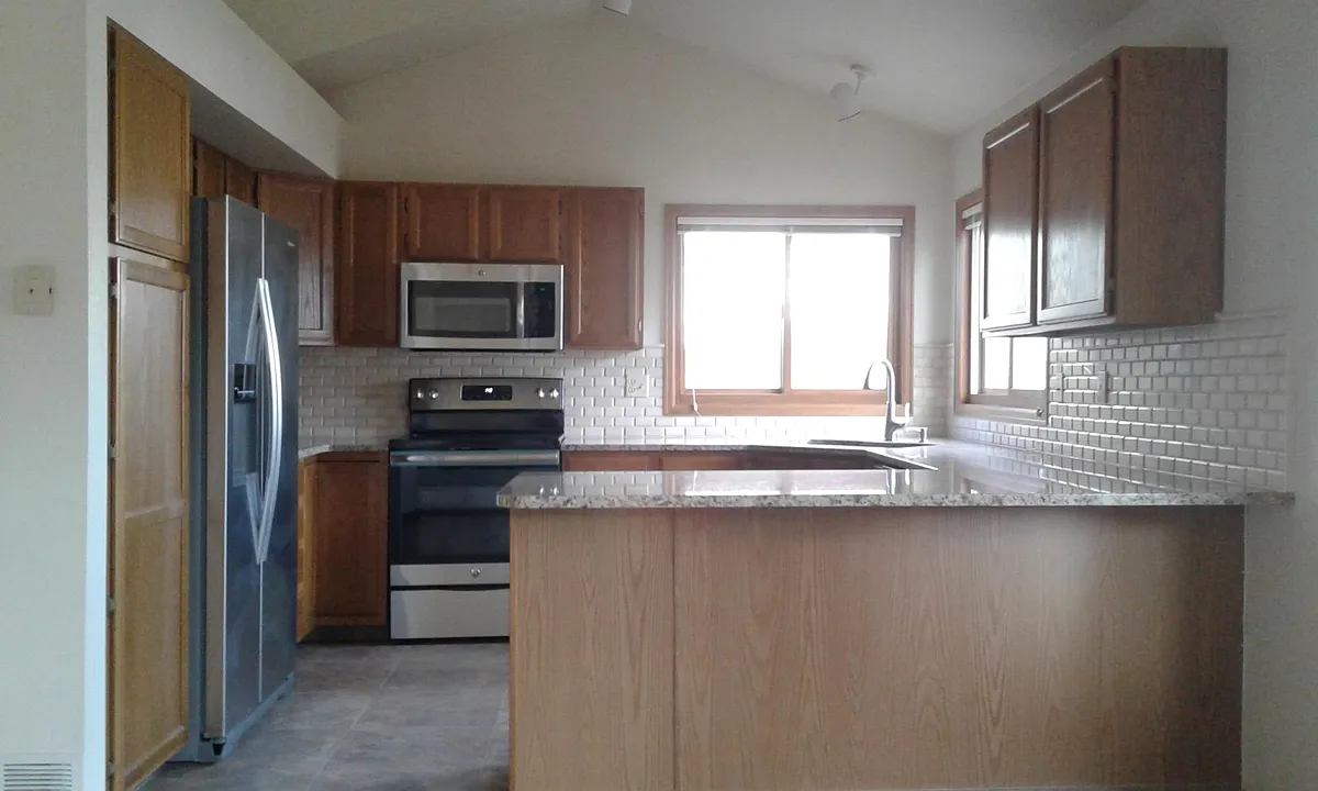 Bright and cherry open concept kitchen with stainless steal appliances, granite and stone backsplash. - 4116 Stonegate Ct