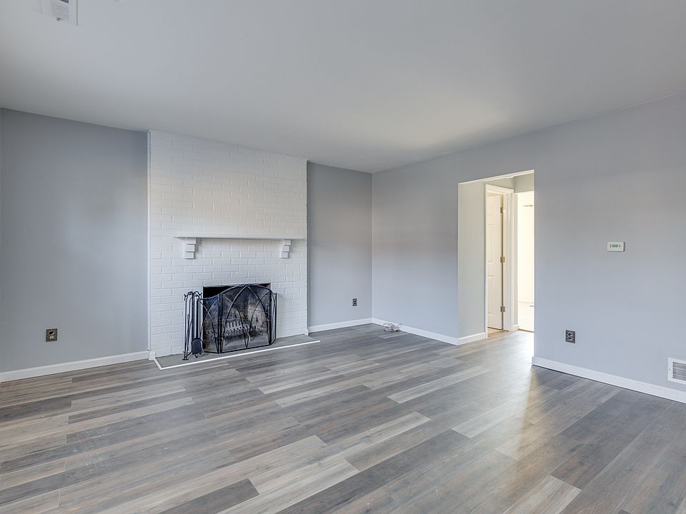 Living room with fireplace, large double hung windows with blinds, large closet