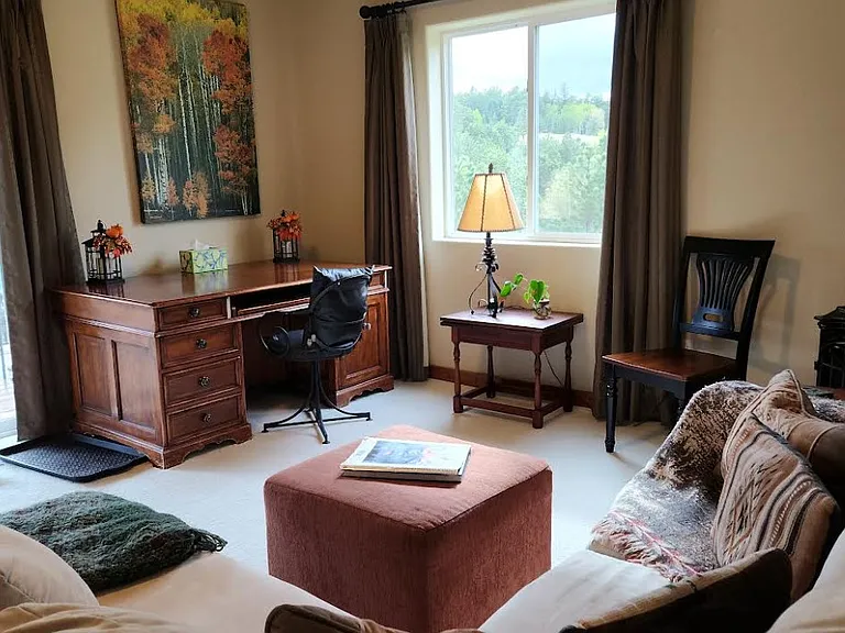 Looking from behind couch at living area and patio doors to deck
