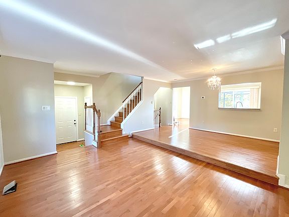 Living Room showing the stairs to upper level and in the distance entrance and passthrough to Kitchen