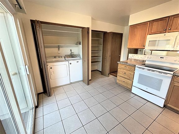 Full size side x side washer and dryer with shelving for laundry storage and full size kitchen pantry