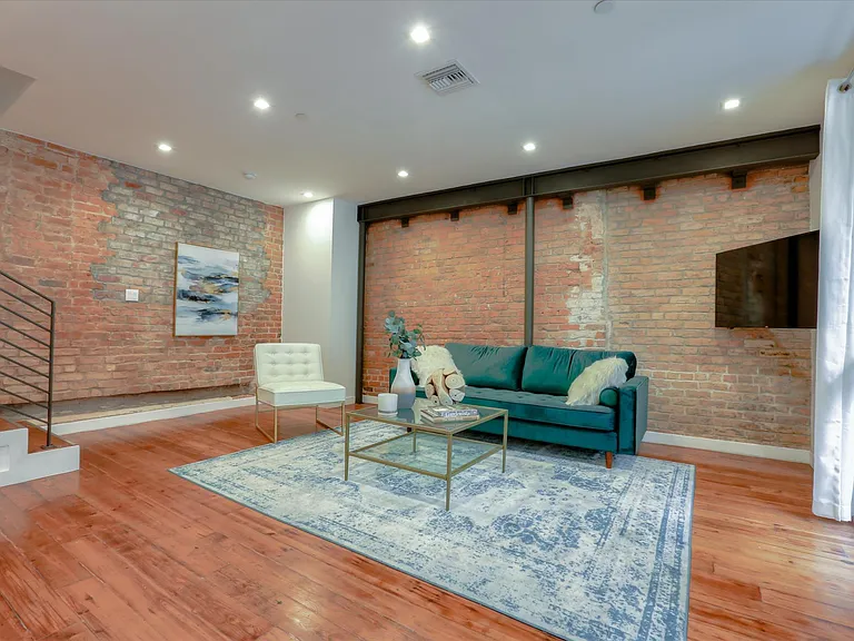 The living area has exposed brick and reclaimed pine hardwood floors from a historic building in the French Quarter.