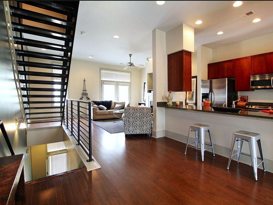 Main Floor: Industrial stairs lead to the kitchen, main room, and dining room. Note French doors leading to balcony off of main room.