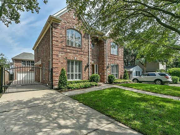 Fresh landscaping and exterior paint and touch up lend to the curb appeal. Note the electric driveway gate and the 2 car garage and garage apartment beyond.
