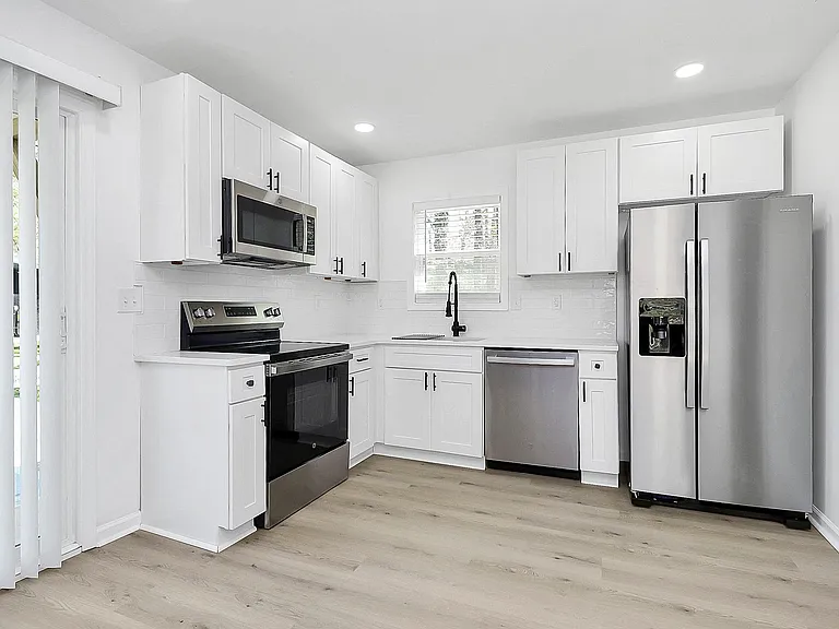 Ample private kitchen with quartz counters and stainless steel appliances.