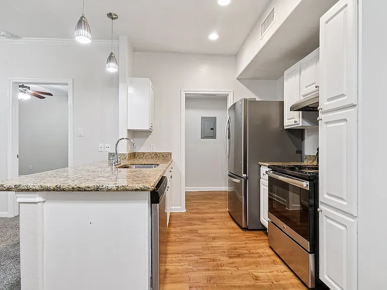 Modern kitchen with granite countertops, stainless steel appliances, and elegant pendant lighting, perfect for entertaining. Modern kitchen with granite countertops, stainless steel appliances, and elegant pendant lighting, perfect for entertaining.