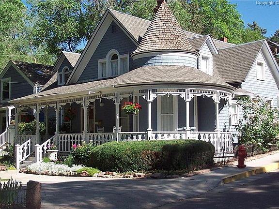 Original railing on wrap around porch featuring a beautiful turret.  You just ca