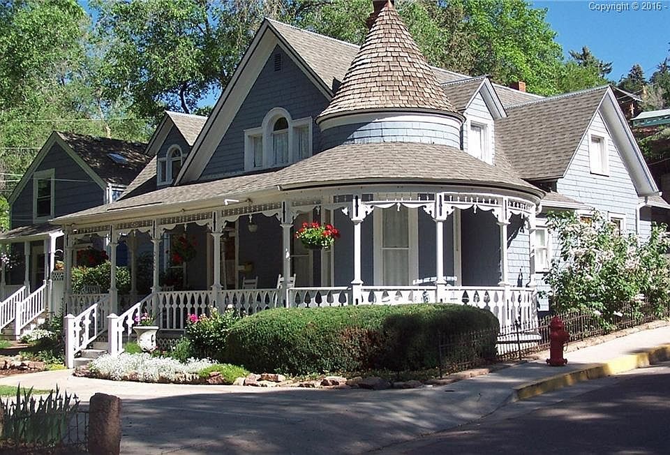 Original railing on wrap around porch featuring a beautiful turret.  You just ca