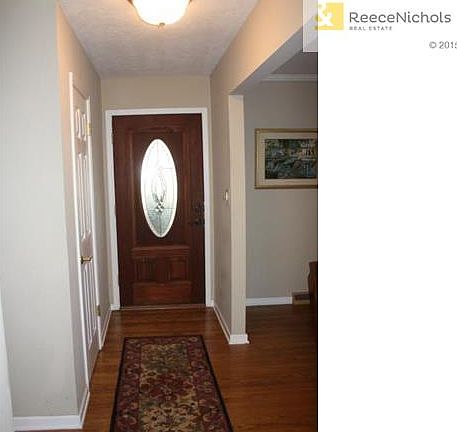 Entry features updated front door and hardwood floors.