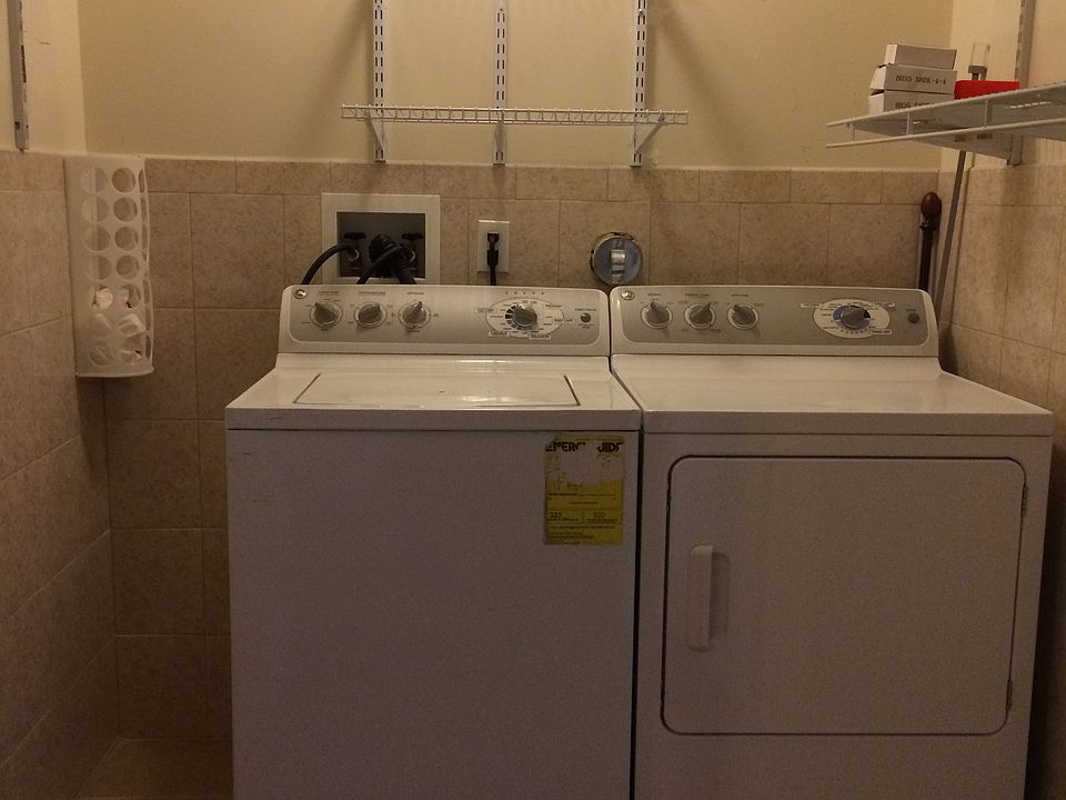Dedicated laundry and pantry room with full-size washer and dryer, plus extra shelving for storage