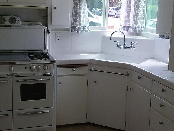 Kitchen - new refrigerator, antique stove recently refurbished, all new tile counter tops and tile floors. Great breeze through kitchen windows. Faces out onto Flower Street. Plenty of storage in kitchen and adjacent laundry room.