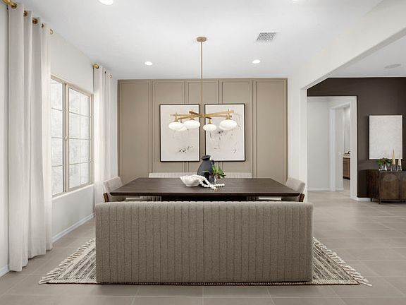 The formal dining space in the Ravenna decorated with trim detail and a decorative light fixture.