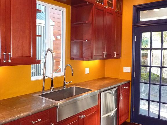 Hammered metal countertops, deep stainless sink and dual dishwasher. Built in wine storage with stained glass details.