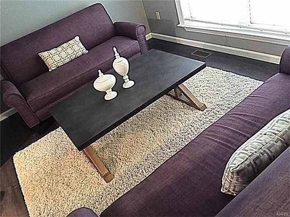 The formal living room is entered from the foyer, and at the left of the photo it is open to the family room.