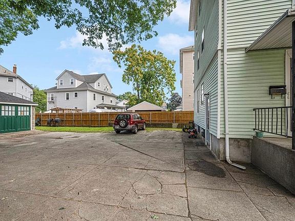 back yard with parking and grassy area
