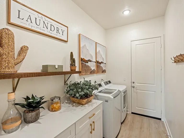 The laundry room features a matching washer and dryer, laundry pods, iron, and ironing board to meet your needs.