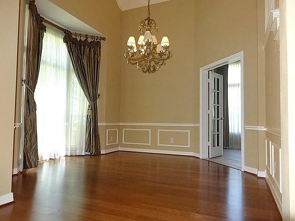  Formal dining with woodfoor, customer drapes, crown moldings, chair rails.