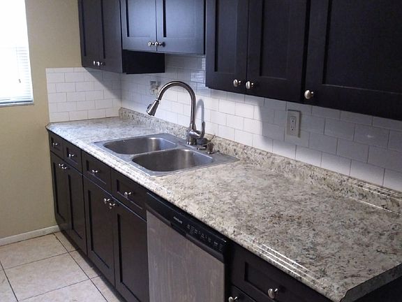 Kitchen with ebony shaker cabinets and subway tile backsplash.