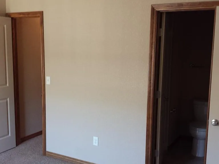 in room looking towards closet (left) and bathroom (right)
