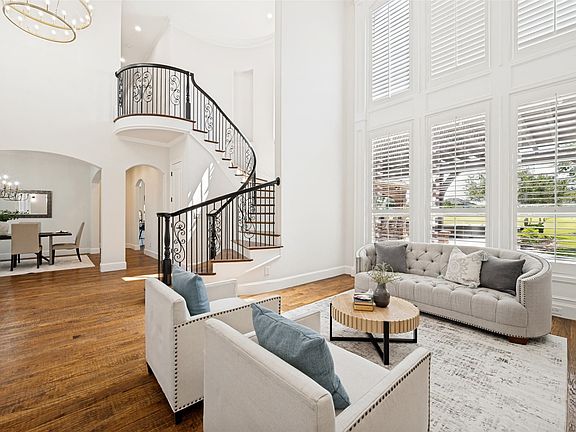The spiral staircase and floor to ceiling windows are focal points for this open concept layout with natural lighting and light palette providing a modern, yet warm aesthetic