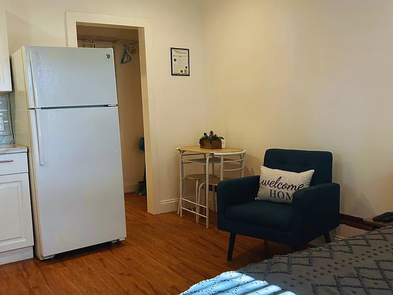 The bedroom features a queen-size bed, a dining table, a ceiling fan, an accent chair and a great lighting.