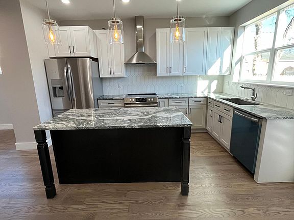 Beautiful kitchen with granite counter tops, large island with sitting area, air fryer oven, and built in microwave.