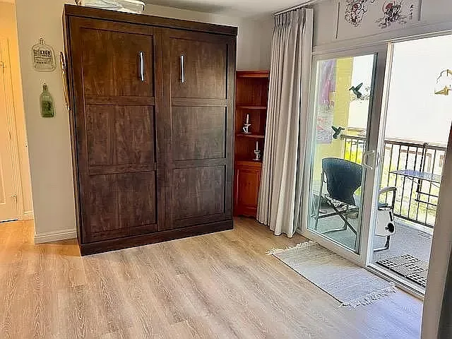 Bedroom 2 has a Queen Murphy bed shown in the closed position so that the room can be used as workout/music/office studio. Large L-shaped closet space back left of photo, leading to private full bath 2.