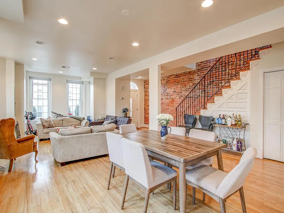 Open concept living room and dining room surrounded with windows.